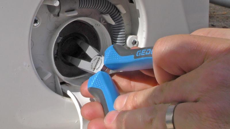 Abgebrochenes Flusensieb mit der Zange aus der Waschmaschine holen Abgebrochenes Flusensieb mit der Zange aus der Waschmaschine holen