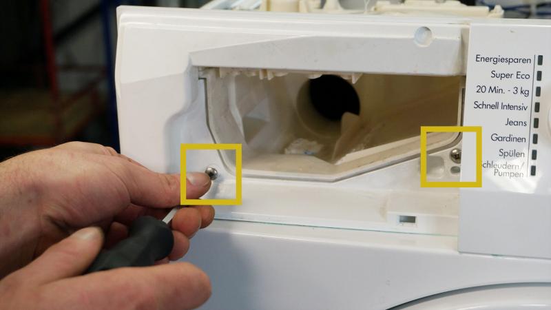Vordere Schrauben der Waschmittelbehälter lösen Vordere Schrauben der Waschmittelbehälter lösen