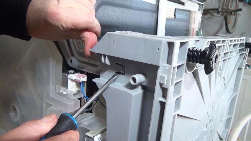 Vordere Verriegelung der Bodenwanne lösen Vordere Verriegelung der Bodenwanne lösen